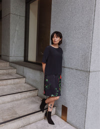 Model wearing a DEVOI black Lise top in plain black silk crepe. Side front full length view.