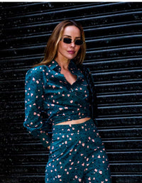 Woman wearing a DEVOI teal and pink leopard print outfit against a dark background