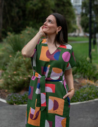 DEVOI green Ivy dress in our Olive Just Pretend print. 100% Linen. Dress has a v-neck, short sleeves and a front and back centre seam. The dress comes with a belt in self fabric to tie at the waist. Front view on model