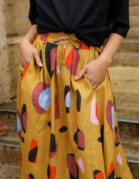 DEVOI Kathleen skirt in new print Mustard Sauros. Elastic waist and pockets. Skirt falls just below the knee. Drawstring tie at front waist. Close-up