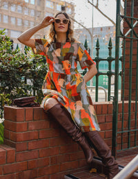 DEVOI Dorothy dress in cotton cord. Printed in Jugs print. Orange and grey colours. Round neckline and gathering at the waist. front sitting view