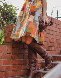 DEVOI Dorothy dress in cotton cord. Printed in Jugs print. Orange and grey colours. Round neckline and gathering at the waist. Side skirt close up view