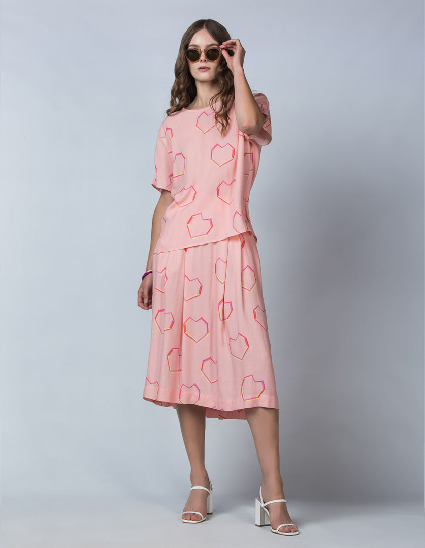 DEVOI Pink Neon Heart printed Margot skirt in modal crepe. Front view on model