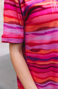 DEVOI Madeleine dress in Sunset tide print. 100% Organic cotton jersey. pink hand painted print. Designed in melbourne. Short sleeves and side pockets.  Close up of sleeve cuff.