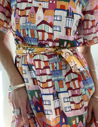 DEVOI White Urban Scapes Dorothy dress in printed Linen. Round neckline. Knee length. Short sleeves. Pockets. Fabric close up on model.