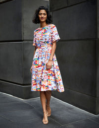 DEVOI White Urban Scapes Dorothy dress in printed Linen. Round neckline. Knee length. Short sleeves. Pockets. Front full length view on model.