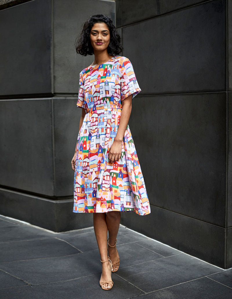 DEVOI White Urban Scapes Dorothy dress in printed Linen. Round neckline. Knee length. Short sleeves. Pockets. Front full length view on model.