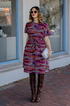 DEVOI Annie dress with a round neckline in Black Sediment print. Black, pink orange and plum colours. Shift dress with a tie belt at the waist. The dress has pockets. Front view.