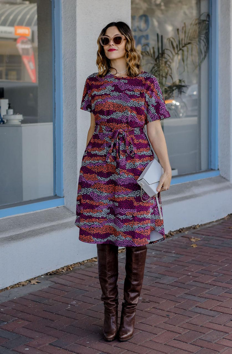 DEVOI Annie dress with a round neckline in Black Sediment print. Black, pink orange and plum colours. Shift dress with a tie belt at the waist. The dress has pockets. Front view.