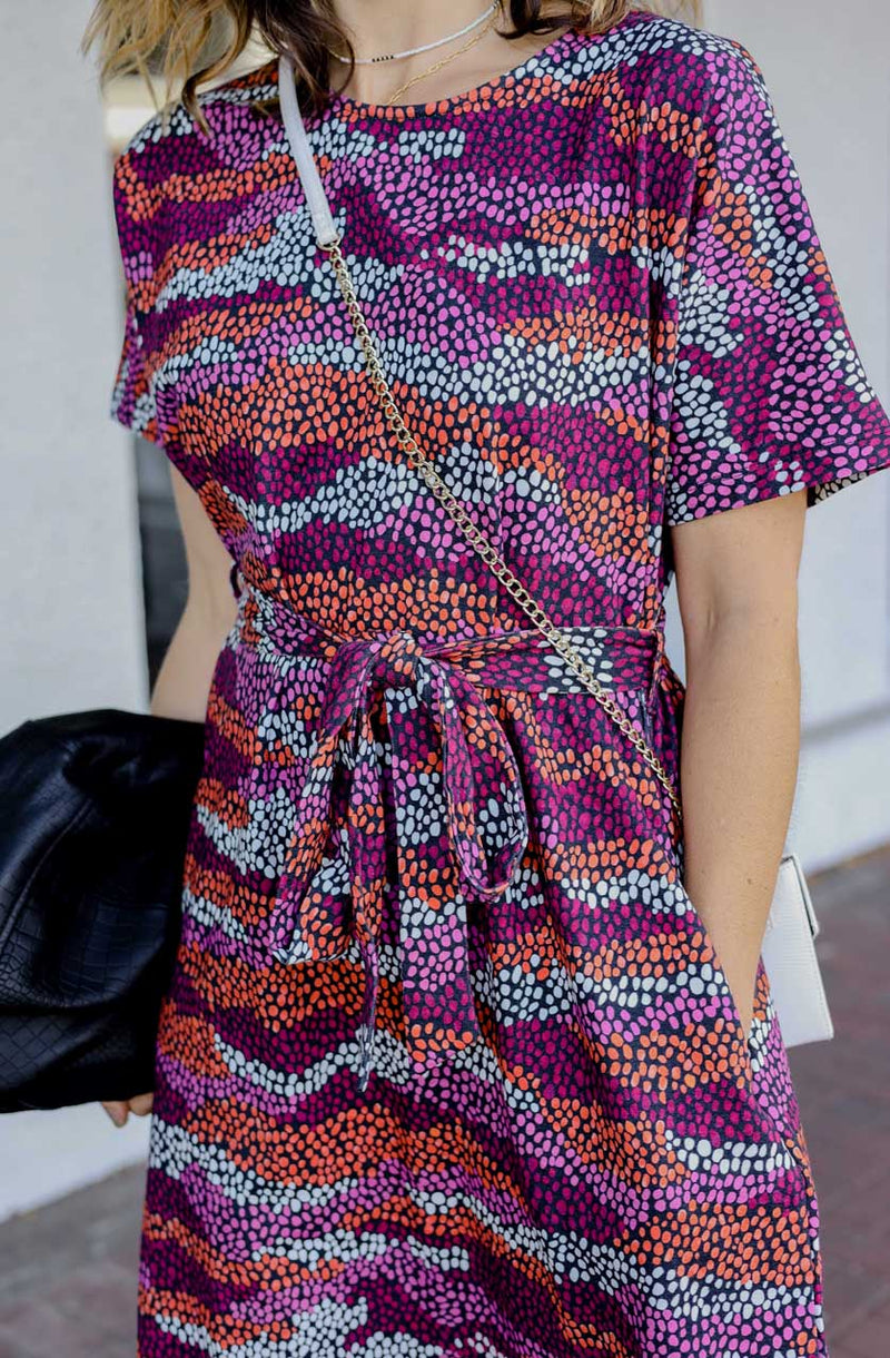 DEVOI Annie dress with a round neckline in Black Sediment print. Black, pink orange and plum colours. Shift dress with a tie belt at the waist. The dress has pockets. front close up