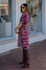 DEVOI Annie dress with a round neckline in Black Sediment print. Black, pink orange and plum colours. Shift dress with a tie belt at the waist. The dress has pockets. Side view