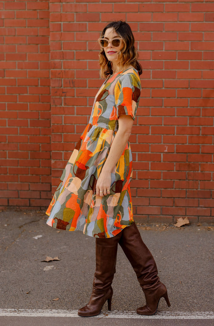 DEVOI Dorothy dress in cotton cord. Printed in Jugs print. Orange and grey colours. Round neckline and gathering at the waist. Side view