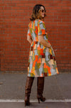 DEVOI Dorothy dress in cotton cord. Printed in Jugs print. Orange and grey colours. Round neckline and gathering at the waist. Back view