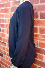DEVOI Everleigh top in black viscose. Long sleeved top with a v-neck, and long sleeves with gathering at the cuff. Elegant black blouse.