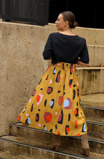 DEVOI Kathleen skirt in new print Mustard Sauros. Elastic waist and pockets. Skirt falls just below the knee. Drawstring tie at front waist.  Back view