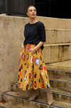 DEVOI Kathleen skirt in new print Mustard Sauros. Elastic waist and pockets. Skirt falls just below the knee. Drawstring tie at front waist. Front view.