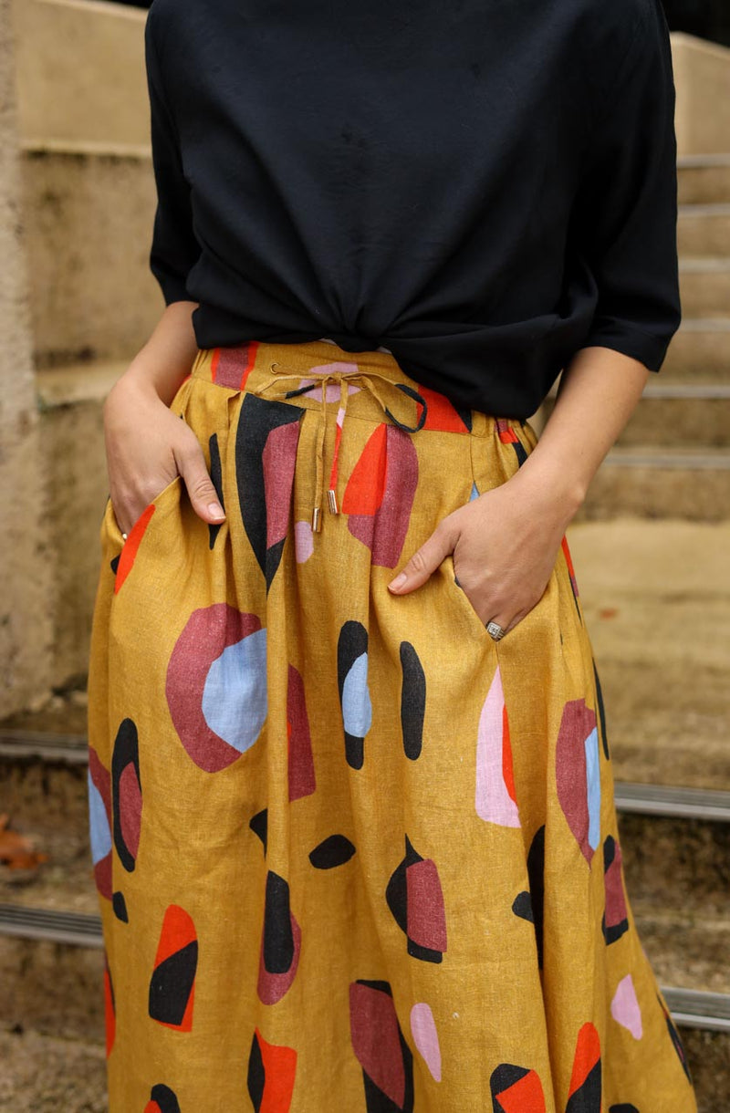 DEVOI Kathleen skirt in new print Mustard Sauros. Elastic waist and pockets. Skirt falls just below the knee. Drawstring tie at front waist.  Close up view