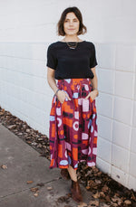 DEVOI Kathleen skirt in our maroon Block Party printed linen. The skirt has an elasticated back waistband and front drawstring tie.  The skirt is a midi length and has pockets.